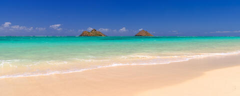 panorama print of the beautiful Lanikai Beach on the Hawaiian Island of Oahu.  Blue sky, amazing water color and the Mokolua Islands on the horizon 