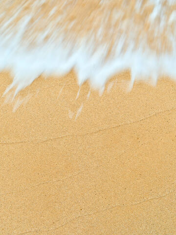 Caress is a beautiful beach abstract images featuring amazing sand textures and an incoming wave coming into the frame. Photography by Andrew Shoemaker