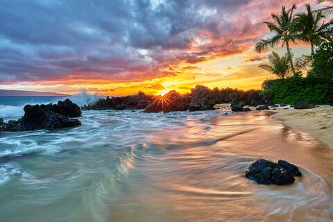beach sunset on a golden sand beach just south of Secret Beach in Makena on the island of Maui with a sun star 