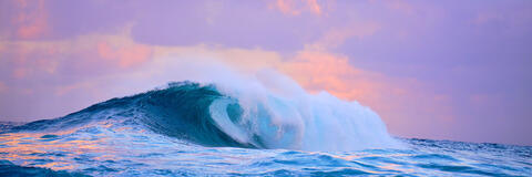 panorama sunset at Jaws (Peahi) on Maui with nice pastel tones as the biggest wave in Hawaii crashes.  Hawaii wave photography from Andrew Shoemaker