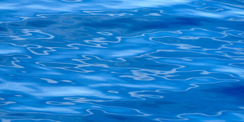 A blue water abstract photography image featuring interesting patterns of the reflections on the surface of the water off the coast of Maui, Hawaii.
