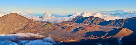 panoramic view of Haleakala Crater during the daylight.  The big island of Hawaii can be seen in the distance.  Photographed by Andrew Shoemaker