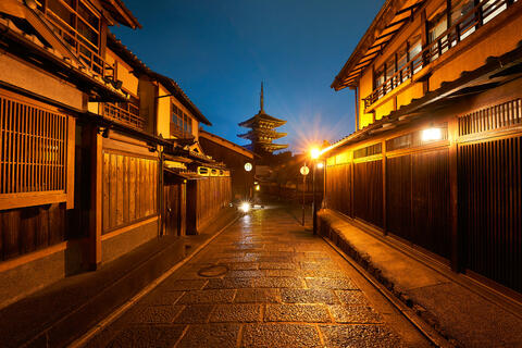 Street view in the well preserved Higashiyama district in Kyoto, Japan with a pagoda in the background at night
