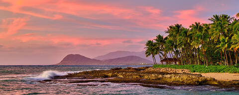 panoramic sunset image looking down the coastline with palm trees from Ko Olina resort on the Hawaiian island of Oahu.  Hawaii Photography by Andrew Shoemaker