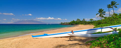 A Hawaiian outrigger canoe in the foreground of the beautiful Maluaka Beach in Makena on the island of Maui, Hawaii.  Fine art nature photography prints 