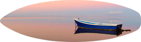 a lone boat reflecting in the mirror like pacific ocean at sunrise on the Hawaiian island of Molokai.  Panoramic photograph by Andrew Shoemaker