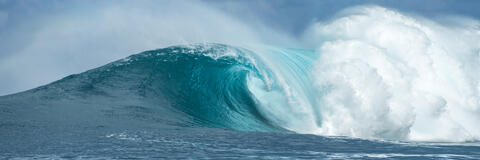 Reign is a panoramic big wave fine art photograph by Andrew Shoemaker featuring the biggest wave in Hawaii breaking and a beautiful barrel with blue water.