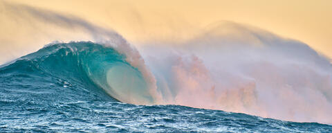 Riptide is a fine art photograph captured at the biggest wave in Hawaii, Jaws at sunset featuring beautiful pastel tones in a panoramic image.