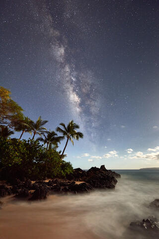 The Milky Way Galaxy rises over Secret Beach in Makena on the island of Maui.  The moon low on the horizon provides lighting for the foregound.  MIlky Way Photo