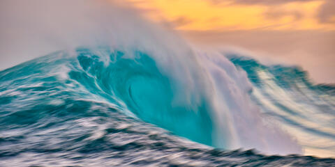 a slow motion capture of the biggest wave in Hawaii Jaws with a vibrant colorful sunrise