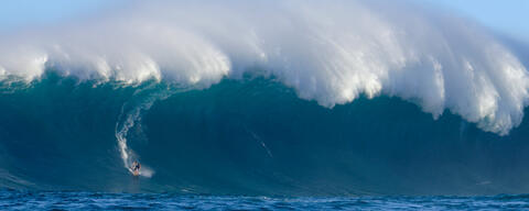 The Wave Rider is a wide panoramic photograph featuring a big wave surfer surfing a giant wave.  Captured at Jaws (Peahi) on Maui by Andrew Shoemaker 