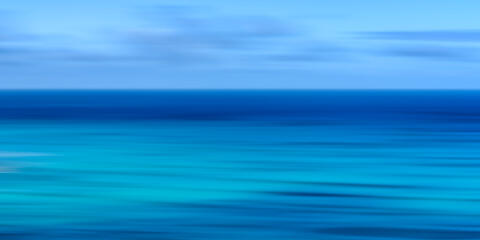 Abstract Waikiki Beach ocean panoramic photography on Oʻahu, Hawaii, featuring intentional camera movement and tranquil blue coastal tones.