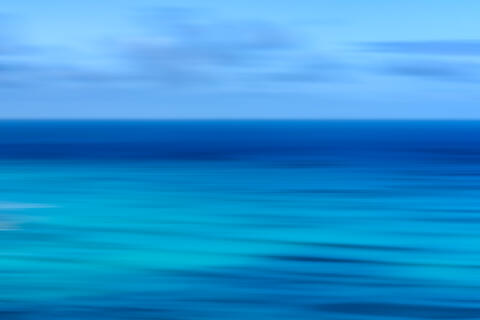 Abstract Waikiki Beach ocean photography on Oʻahu, Hawaii, featuring intentional camera movement and tranquil blue coastal tones.
