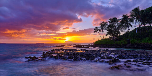 panoramic sunset with purple and violet tones at Secret Beach in Makena on the island of Maui