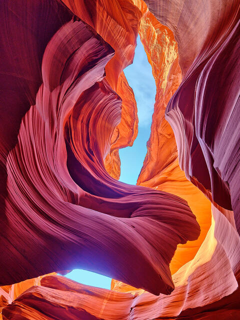 a beautiful photograph in lower antelope canyon resembling an angel with wings.  Contrasting colors or purple, red, and orange make up this Arizona scene