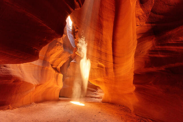a beautiful fine art photograph in upper Antelope Canyon in Page, Arizona with an arrowhead shape in a light beam entering the canyon.  Arizona Photography Art