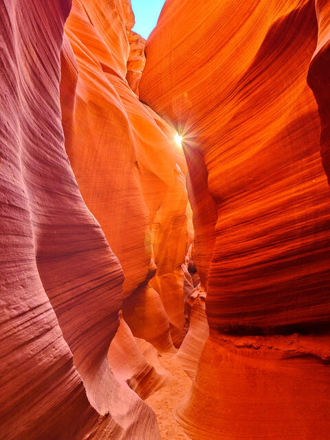 a sun star breaks through lower antelope canyon in Page, Arizona.  The slot canyons are incredible to photograph and artist Andrew Shoemaker sees the light