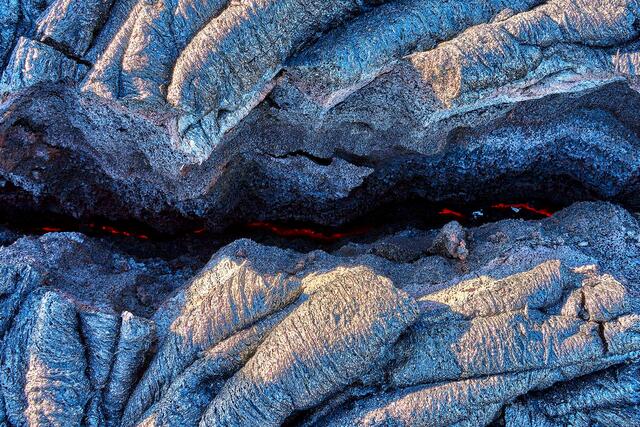 the earth is glowing red hot through a crack in the dried lava on the big island of Hawaii.  Lava Photography by Andrew Shoemaker