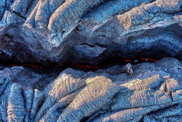 the earth is glowing red hot through a crack in the dried lava on the big island of Hawaii.  Lava Photography by Andrew Shoemaker