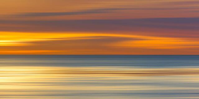 Abstract California sunset with golden light sweeping across the Pacific Ocean
