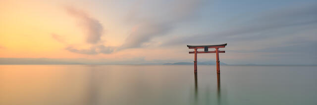 Continuance is a fine art panoramic photograph featuring a floating Torii gate at sunrise on Lake Biwa in Shiga, Japan.  Japan photography by Andrew Shoemaker