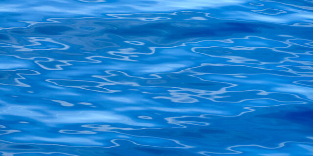 A blue water abstract photography image featuring interesting patterns of the reflections on the surface of the water off the coast of Maui, Hawaii.