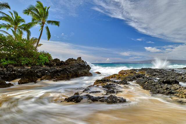 Ebb and Flow is a beautiful tropical photograph at Secret Beach on the Hawaiian island of Maui featuring palm trees and incoming and outgoing waves