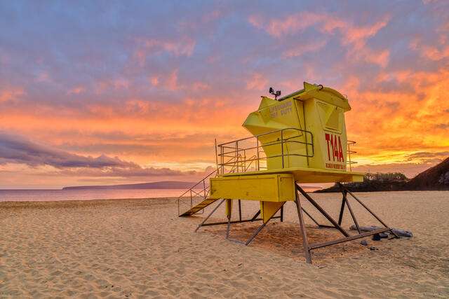 Ember is a fiery beach sunset with the lifeguard shack at the beautiful Makena Beach State Park on the island of Maui.  Photographed by Andrew Shoemaker 