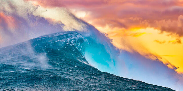 panoramic photograph of the biggest wave in Hawaii Jaws at sunrise with very vibrant and dramatic colors.  Photographed on the North Shore of Maui 