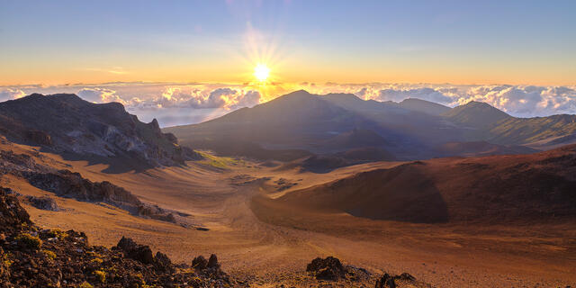 sunrise panorama overlooking Haleakala Crater with a sunstar at Haleakala National Park on the island of Maui