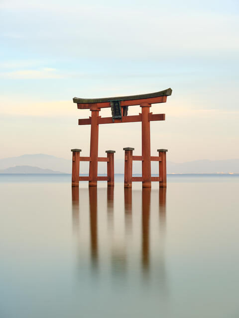 Inner Peace is a peaceful long exposure photograph of an orange torii gate at Shirahige temple located on Lake Biwa in Japan.  Photograph by Andrew Shoemaker