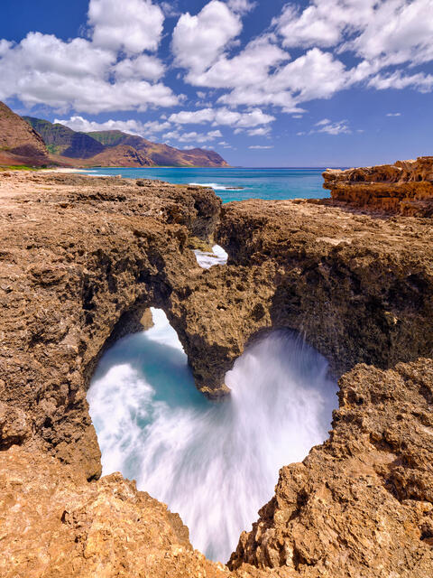photograph of a heart shaped rock formation with incoming waves on the west side of the hawaiian island of Oahu. High resolution photography by Andrew Shoemaker