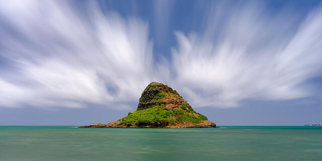 a long exposure of chinaman's hat on the hawaiian island of Oahu.  Also known as Mokoli'i Island, a beautiful scene captured by photographer Andrew Shoemaker