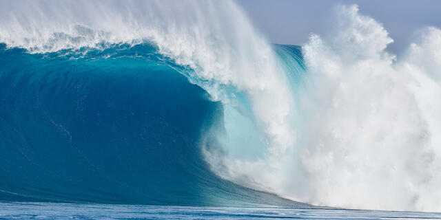 Massive blue Hawaiian wave breaking with powerful ocean spray, showcasing the raw beauty and energy of the Pacific Ocean.