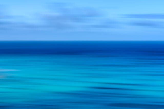 Abstract Waikiki Beach ocean photography on Oʻahu, Hawaii, featuring intentional camera movement and tranquil blue coastal tones.