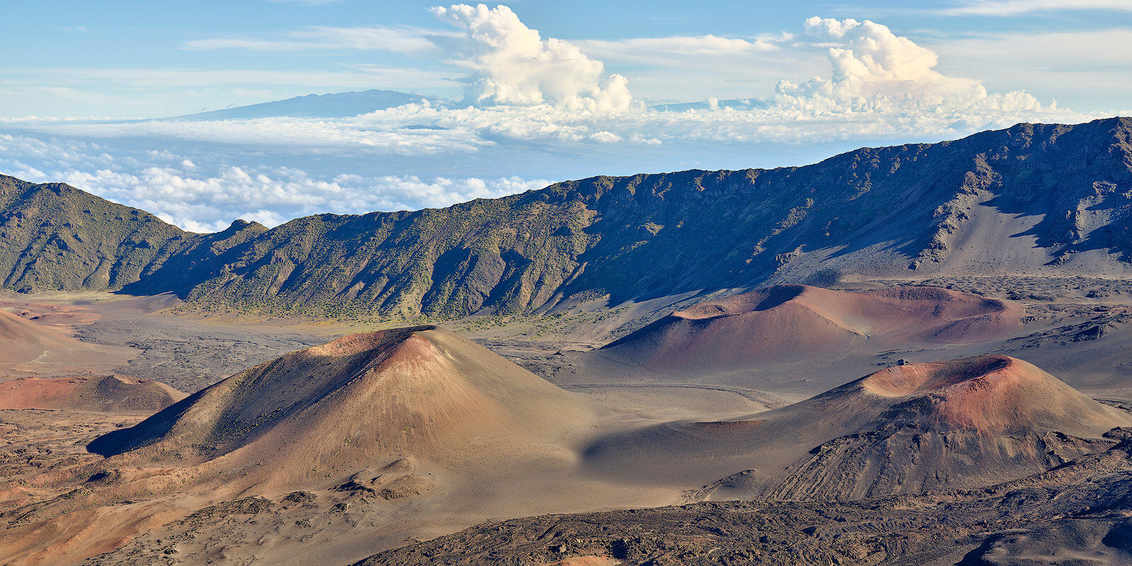 looking across Haleakala crater on the island of Maui with cinder cones in the foreground.  Mauna Loa and Mauna Kea can be seen in the distance miles away