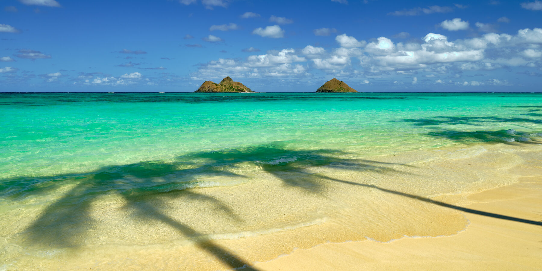 Serendipity is a fine art photograph from Andrew Shoemaker at Lanikai Beach on the Hawaiian island of Oahu featuring azure waters and two islands on the horizon