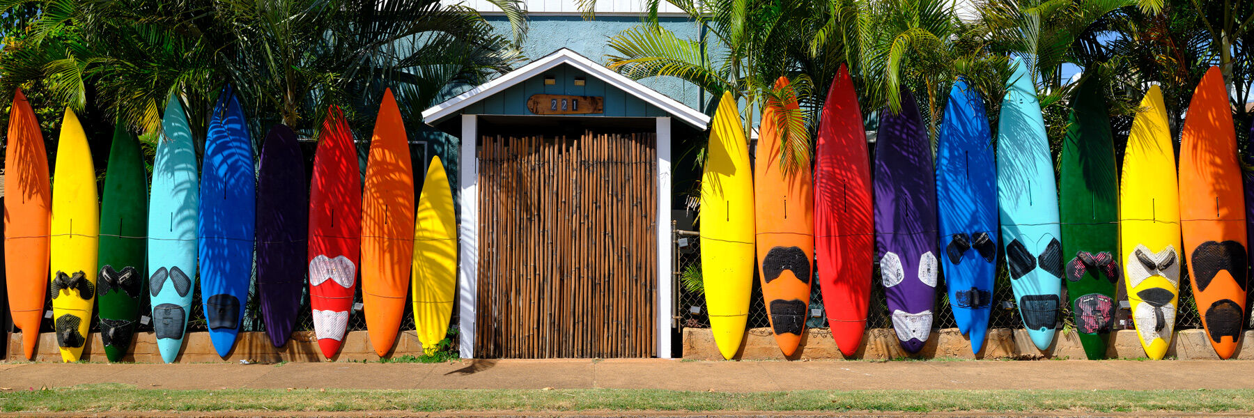 Aloha Surf a colorful surfboard fence at the Aloha Surf Hostel located in the town of Paia in Maui, Hawaii photographed by fine art photographer Andrew Shoemaker