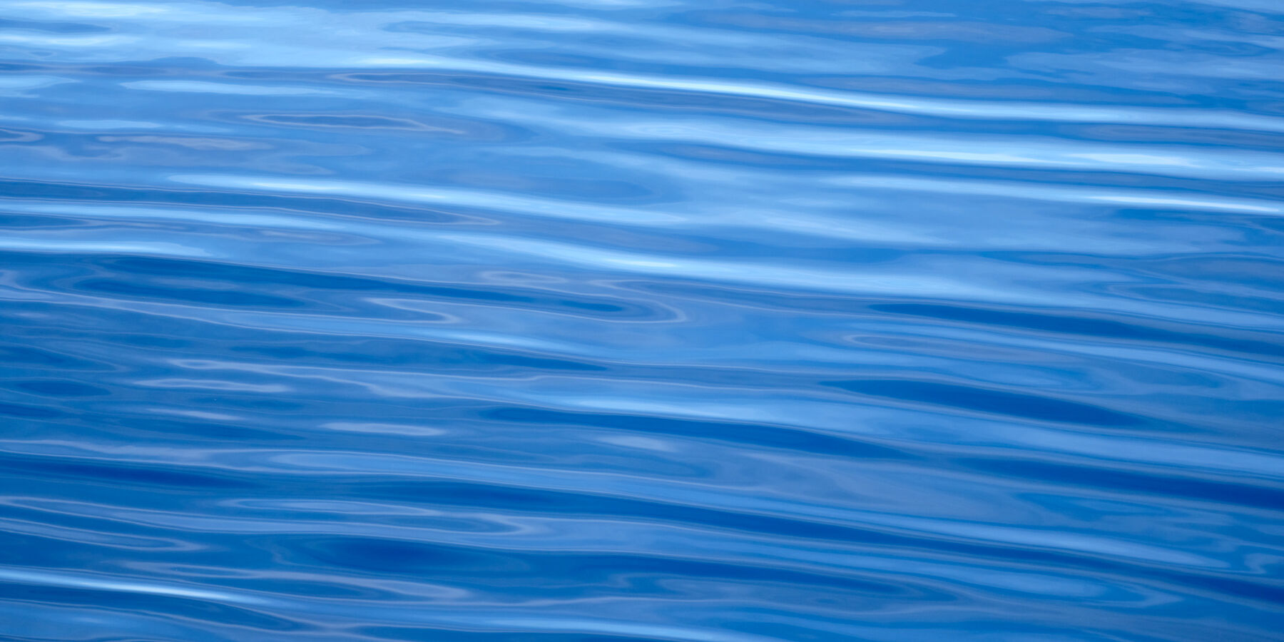 Blue Crystal Panorama an abstract blue panoramic image of the beautiful pacific ocean photographed off the coast of Maui, Hawaii. Abstract photography by Andrew Shoemaker