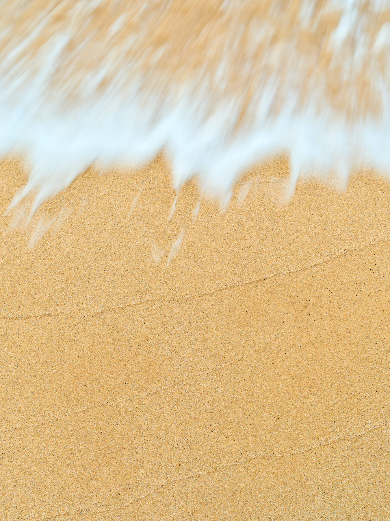 Caress Caress is a beautiful beach abstract images featuring amazing sand textures and an incoming wave coming into the frame. Photography by Andrew Shoemaker