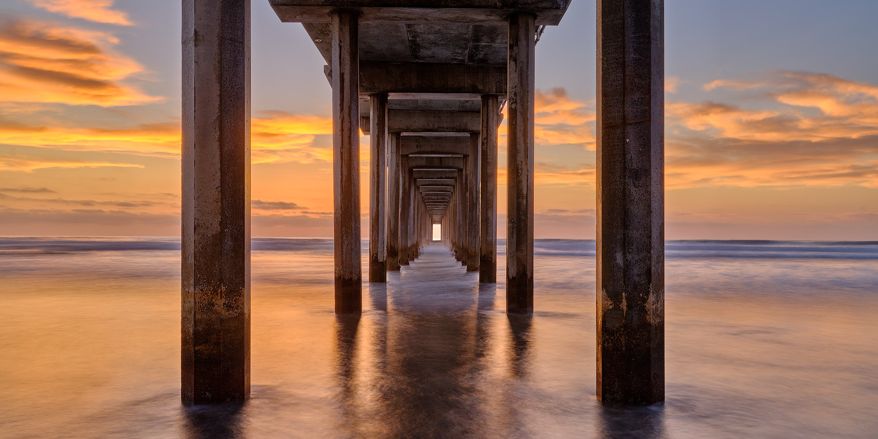 Dimension a panoramic photograph looking down Scripps Pier in La Jolla, California captured by fine art landscape photographer Andrew Shoemaker