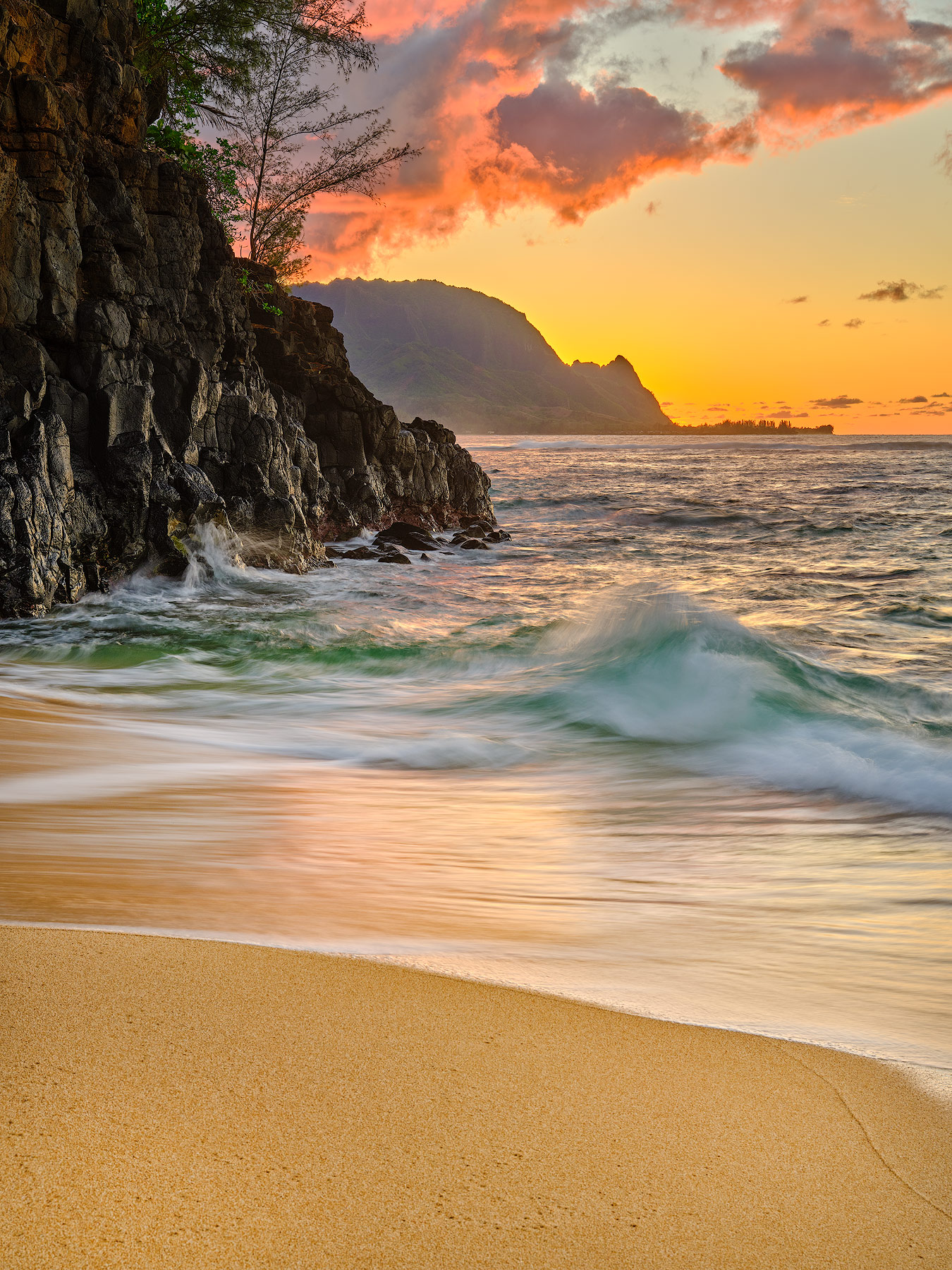 a beautiful sunset captured looking down the Na Pali coastline of Kauai from Hideaways Beach near Hanalei, Hawaii.  Hawaii photography by Andrew Shoemaker