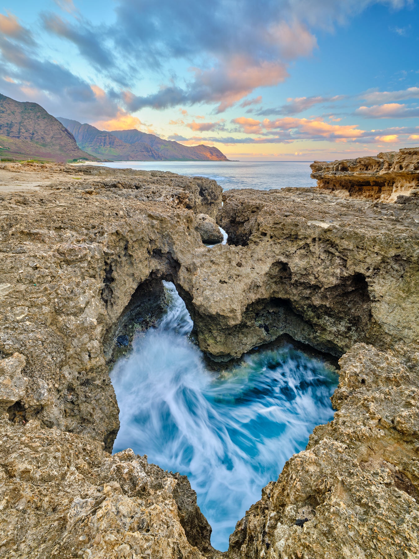 Heart of the Aina is a fine art photograph by Andrew Shoemaker showing a heart shaped rock formation on Oahu at sunset which is formed from incoming waves.