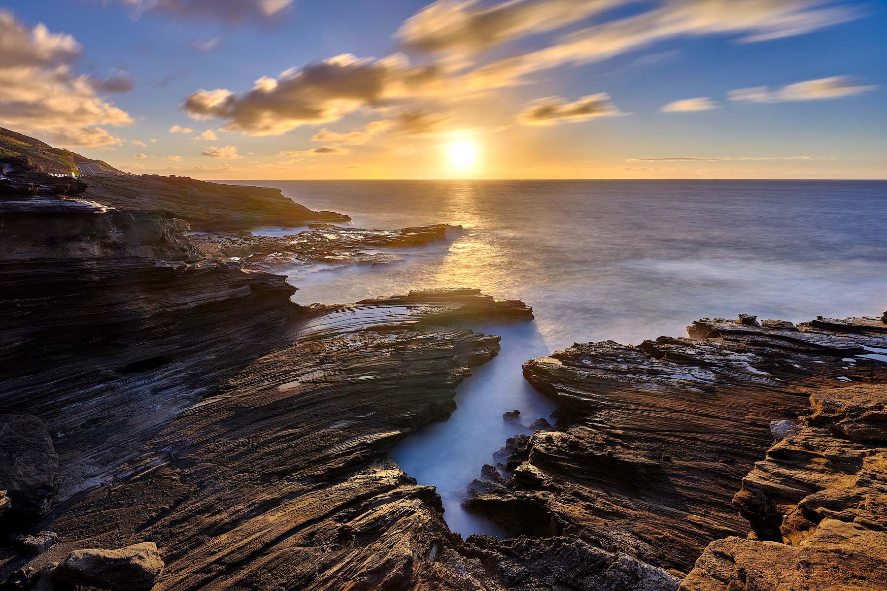 Inception Golden sunrise over the volcanic rock formations and flowing ocean water at Lānaʻi Lookout on Oʻahu, Hawaii.