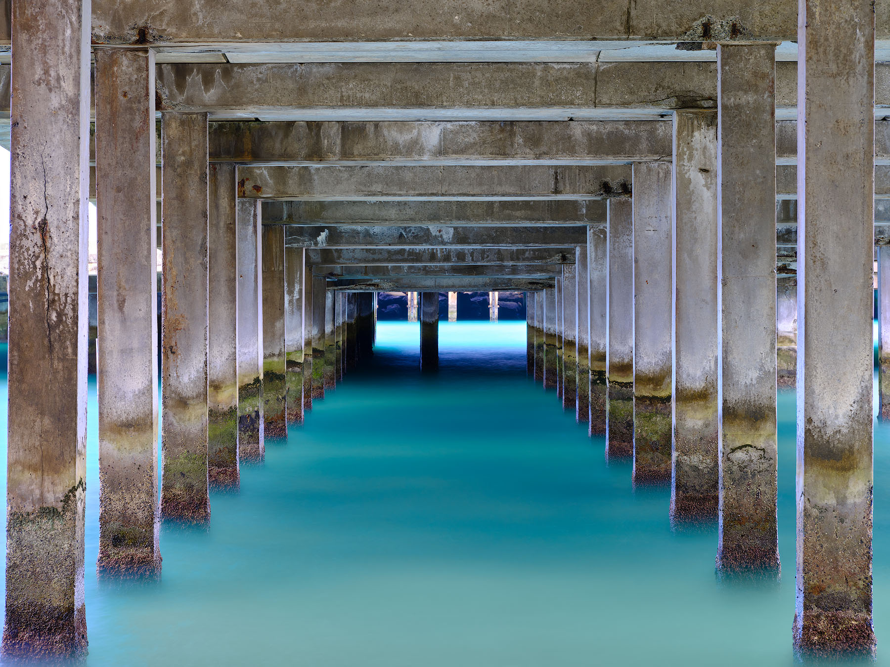 Poseidon's Gate is a photograph down the Makai Research Pier on the Hawaiian island of Oahu showcasing symmetry and the beautiful Hawaii water color