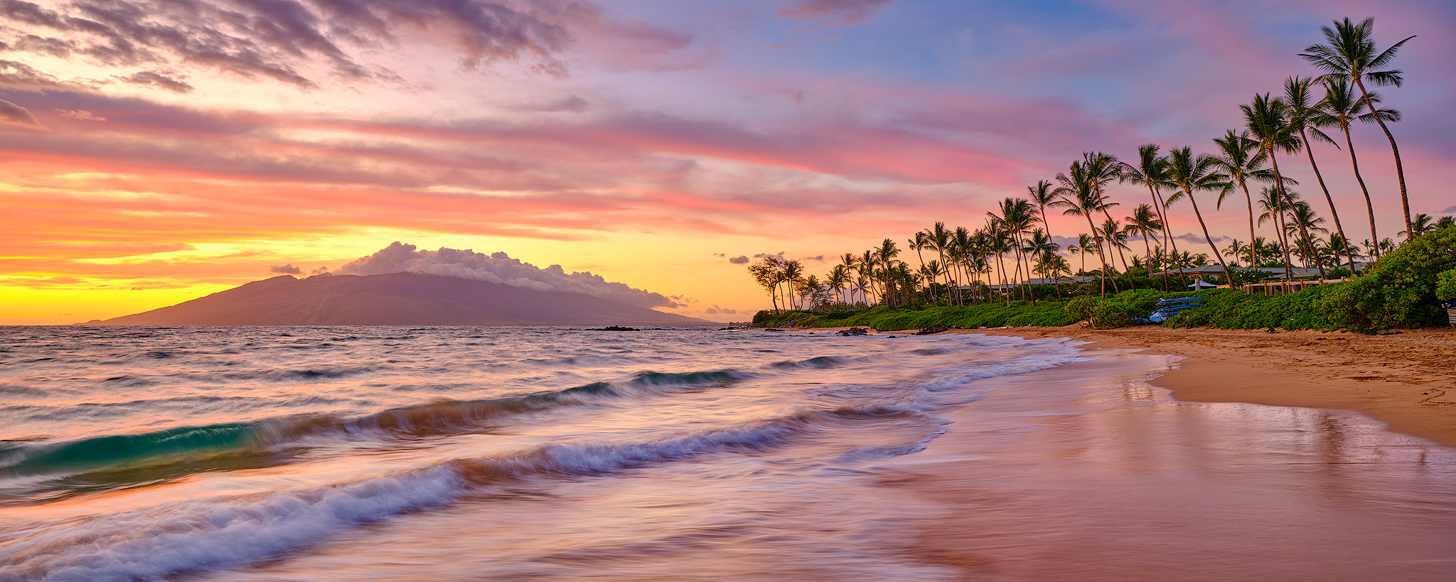 a beautiful beach sunset looking down the coconut palm lined Mokapu Beach located in Wailea on the Hawaiian island of Maui.  Photography by Andrew Shoemaker