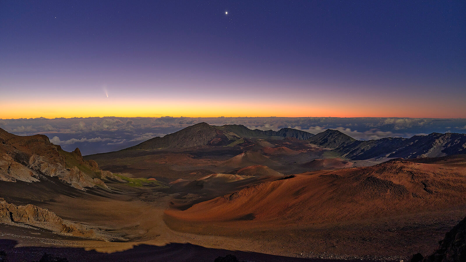 panoramic view of Haleakala Crater just before sunrise with the Neowise comet on the horizon