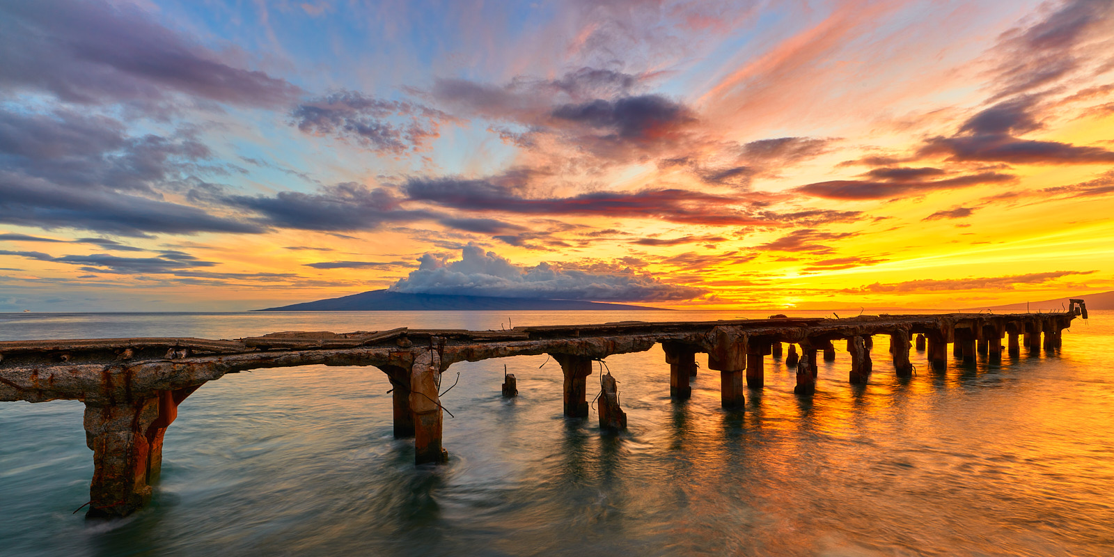 a very vibrant sunset captured at Mala Lamp extending into the ocean in Lahaina on the island of Maui.  Hawaii Panorama photographed by Andrew Shoemaker