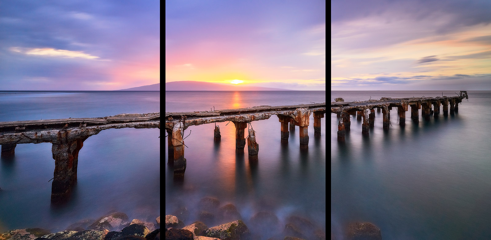 long exposure sunset panoramic photograph at Mala Ramp in Lahaina, Maui.   The sun is setting behind the island of Lanai and creating a purple tone throughout 