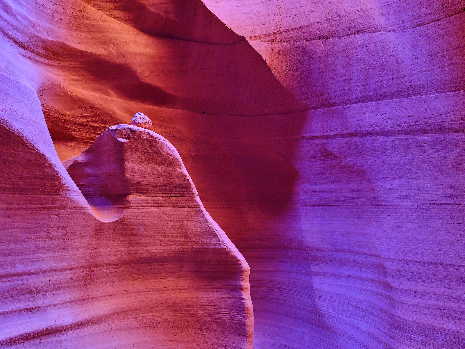 a fine art photograph inside of Antelope Canyon in Page, Arizona with a rock that has landed on top of one of the walls. Arizona Photography by Andrew Shoemaker